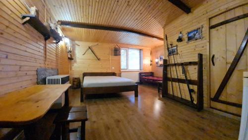Habitación con cama y pared de madera. en Usadba Okhotnichiy Dvor, en Yabluniv