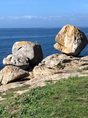 two large rocks sitting on top of the ocean at Maison Castel Braz in Pont-Aven