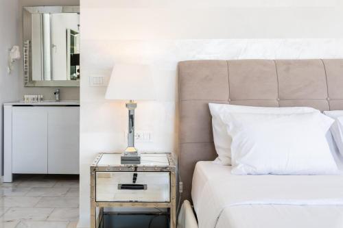 a bedroom with a bed and a side table with a lamp at Villa Deloxenia by Ethos Hospitality in Mikonos