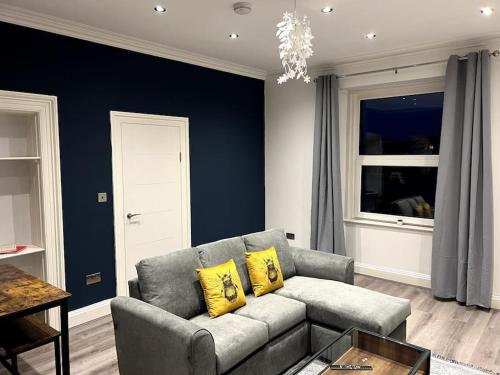 a living room with a gray couch and yellow pillows at Modern Cotham House by Prescott Apartments in Bristol