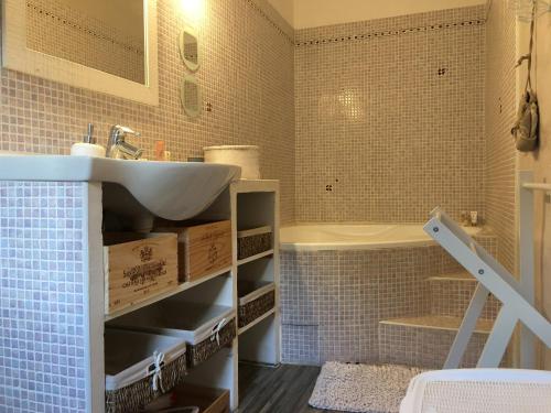 a bathroom with a sink and a tub at Le Baratier - Demeure de charme Sauna & Piscine in Calvisson