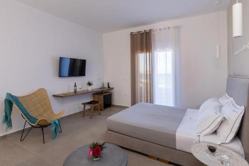 a bedroom with a bed and a tv and a chair at Vivianna's View in Azolimnos Syros