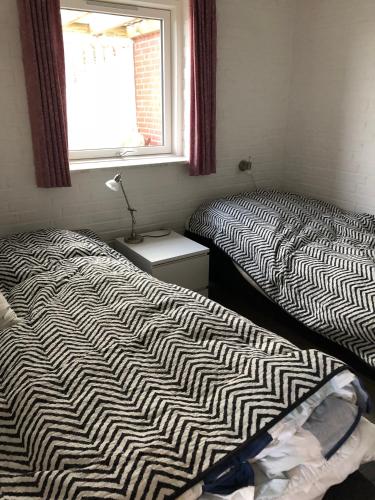 2 camas individuales en una habitación con ventana en Hel(t) udlejningsbolig med Christina som vært, en Gråsten