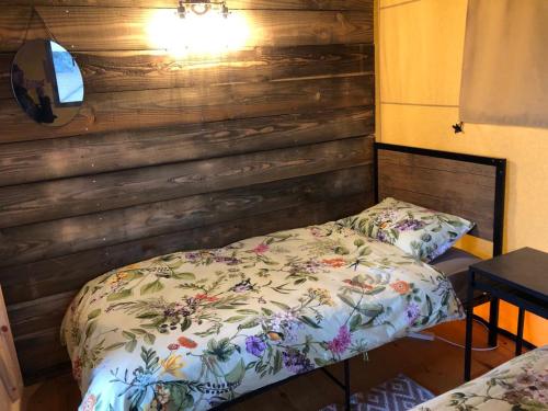 a bedroom with a bed and a wooden wall at The Paddock in Bredon