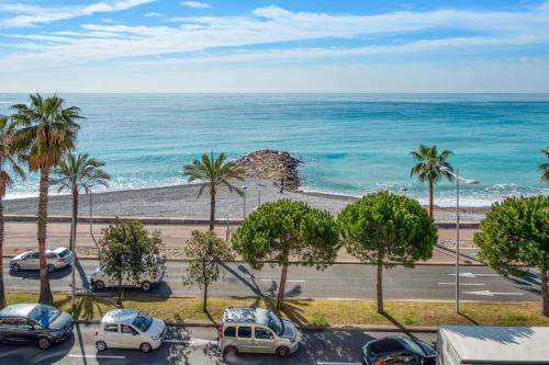- une vue sur une plage avec des palmiers et des voitures dans l'établissement Appartement Rivage - Welkeys, à Cagnes-sur-Mer