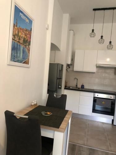 - une petite cuisine avec une table et des chaises dans la chambre dans l'établissement Le Saint-Michel, à Menton