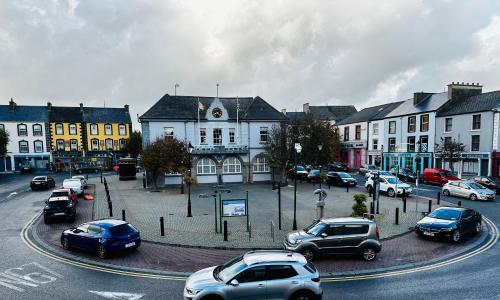 a city with cars parked on a street with buildings at Zoe Bistro & Accommodation in Kilrush
