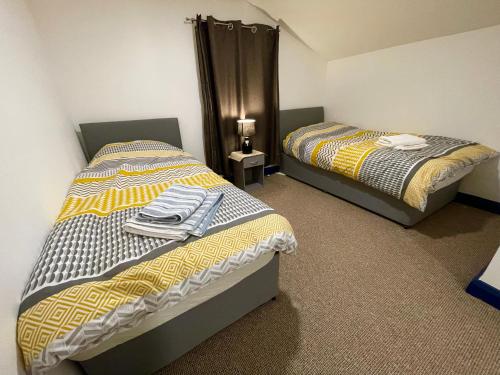 two beds sitting next to each other in a room at Cathedral view Cottage in Gloucester