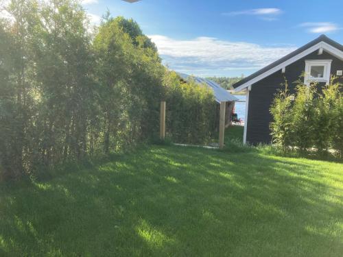 a yard with a fence and a house at Brygghuset, Solviken in Rockneby
