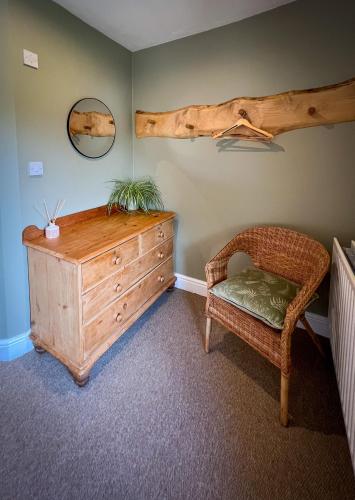 a room with a wooden dresser and a chair at New Ing Lodge in Shap
