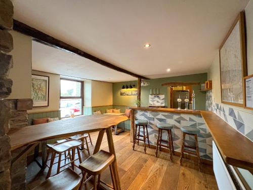 eine Küche mit einer langen Bar mit Hockern in der Unterkunft New Ing Lodge in Shap