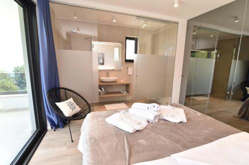 a bedroom with a large bed with towels on it at Villa Bella Vista 2 in Ičići