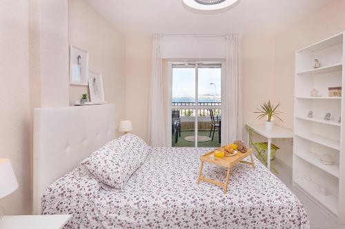 Sunshine Balcony- La Caleta في كاليتا دي فيليز: غرفة نوم بيضاء مع سرير وطاولة
