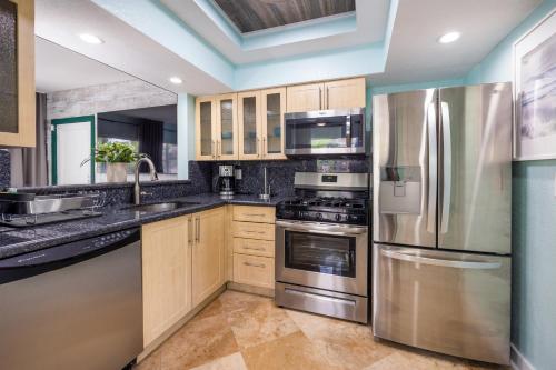 a kitchen with stainless steel appliances and wooden cabinets at Suites on South Beach in Miami Beach