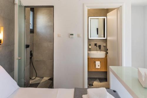 a bathroom with a bed and a sink and a mirror at Lobster in Leptokaria