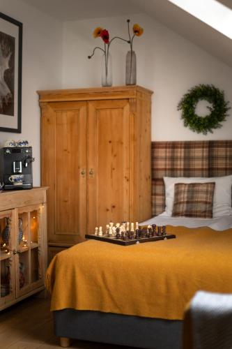 a bedroom with a bed with a chess board on it at Apartamenty U Harrego I Przy Stawie Spa z klimatyzacją, balia, sauna, ogrodem i parkingiem in Kudowa-Zdrój