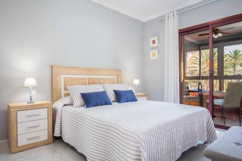 a bedroom with a large bed with blue pillows at RELAX JANDIA in Morro del Jable