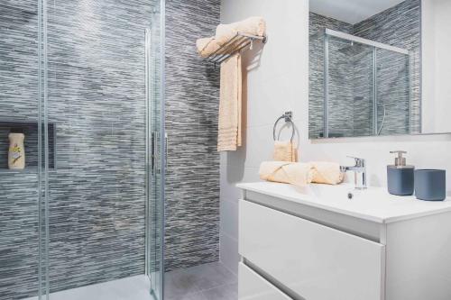 uma casa de banho com uma cabina de duche em vidro e um lavatório. em RELAX JANDIA em Morro del Jable