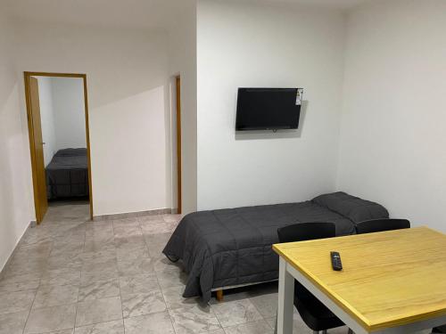 Zimmer mit einem Bett, einem Tisch und einem TV in der Unterkunft Don Benja in Federación