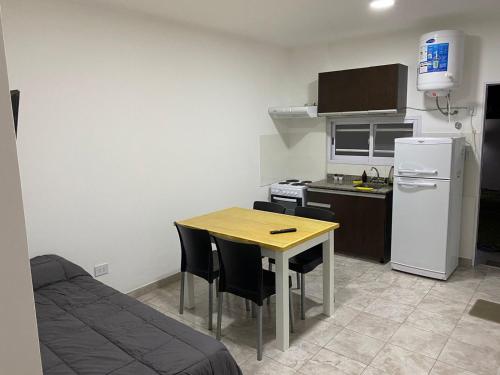 a small kitchen with a table and a refrigerator at Don Benja in Federación