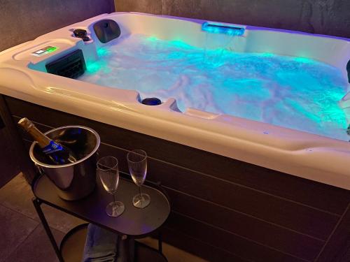 a bath tub with two wine glasses and a bottle of champagne at Spa & vue Mer - Les Ô de Bandol in Bandol