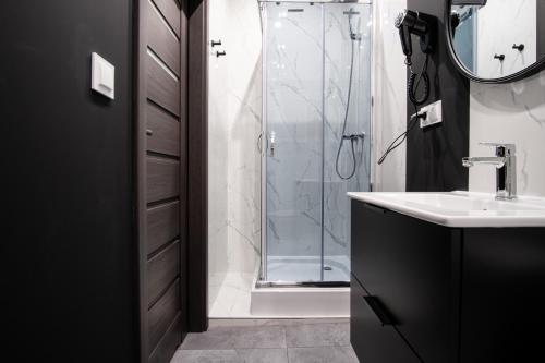 a bathroom with a glass shower and a sink at Dream Aparts - Piotrkowska 56 in Łódź