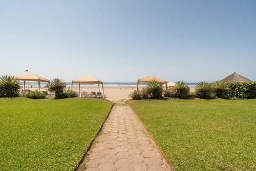 a walkway leading to a beach with umbrellas at Maravilloso departamento frente al mar, Acapulco in Acapulco