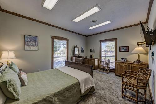 a bedroom with a bed and a desk and windows at Halpino in Vicksburg