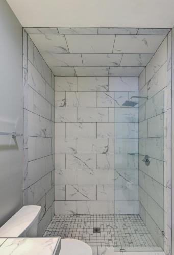 a bathroom with a shower with white tiles at Halpino in Vicksburg