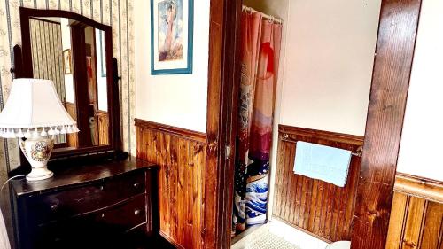 a room with a mirror and a lamp on a dresser at Hotel La More at The Bisbee Inn in Bisbee