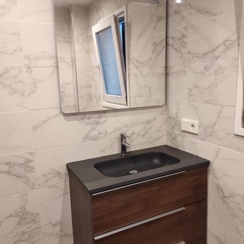 een badkamer met een zwarte wastafel en een spiegel bij Apartamento Amezti in Elizondo