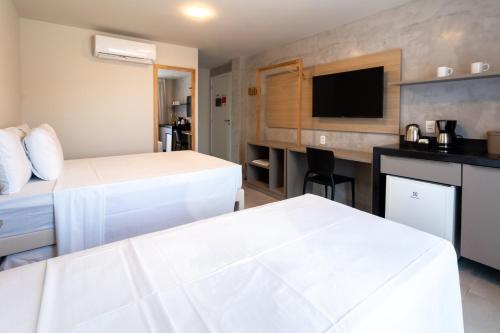 a hotel room with two beds and a flat screen tv at Liiv Mar - Natal Ponta Negra in Natal