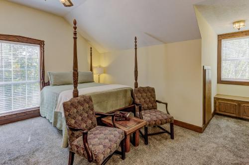 a bedroom with a bed and two chairs and a window at Halpino in Vicksburg