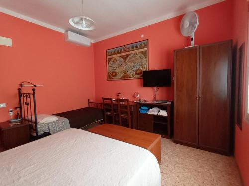 - une chambre avec des murs rouges, un lit et une télévision dans l'établissement B&B Falcone, à Ortona