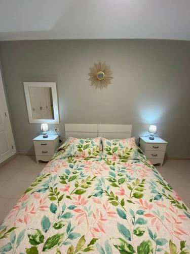 a bedroom with a bed with a floral bedspread at Apartamento en Costa Adeje in Adeje