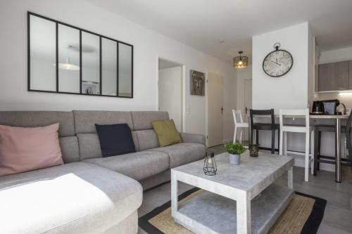 un salon avec un canapé et une table dans l'établissement Appartement Grigio - Welkeys, à Anglet