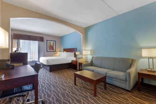 um grande quarto de hotel com uma cama e um sofá em Best Western Plus Suites Greenville em Greenville