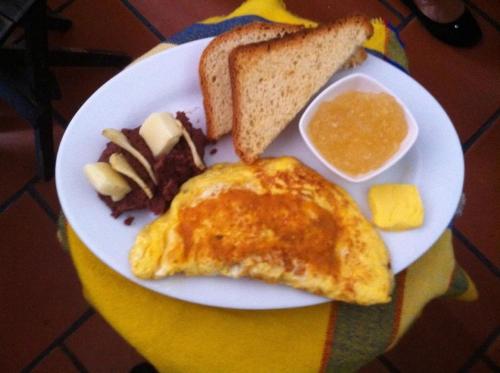 a plate of breakfast food with an omelet and bread at Hotel Plaza Yat Balam Anexo in Copán Ruinas