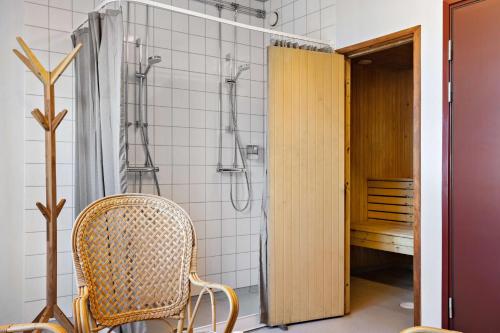 La salle de bains est pourvue d'une chaise et d'une douche. dans l'établissement Sure Hotel by Best Western Dalhall, à Åmål
