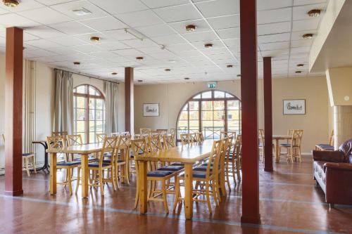a dining room with wooden tables and chairs at Dalhall Hotell in Åmål
