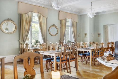 ein Esszimmer mit Holztischen und -stühlen in der Unterkunft Amals Stadshotell, Sure Hotel Collection by Best Western in Åmål