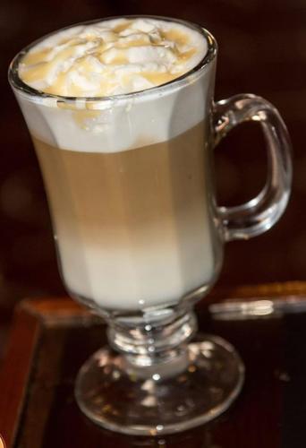a glass mug of coffee sitting on a table at Hotel Plaza Yat Balam Anexo in Copan Ruinas