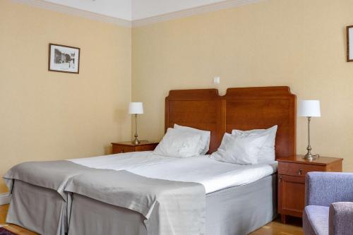 a bedroom with a large bed with white sheets and pillows at Amals Stadshotell, BW Signature Collection in Åmål