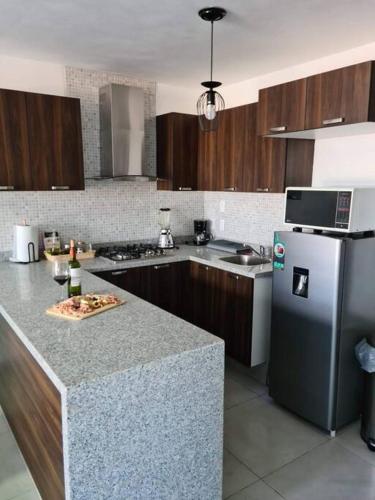 a kitchen with a counter top and a refrigerator at Depa con AC y Alberca en el centro de Guadalajara in Guadalajara