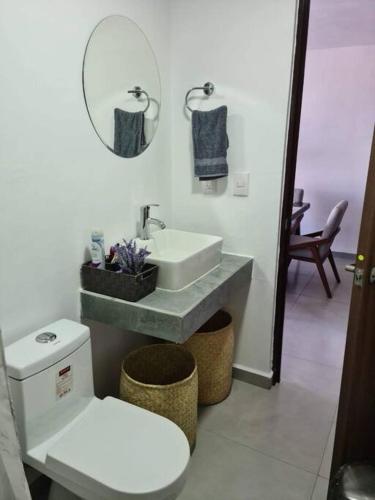 a bathroom with a sink and a toilet and a mirror at Depa con AC y Alberca en el centro de Guadalajara in Guadalajara