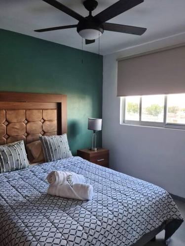 a bedroom with a bed with a white towel on it at Depa con AC y Alberca en el centro de Guadalajara in Guadalajara