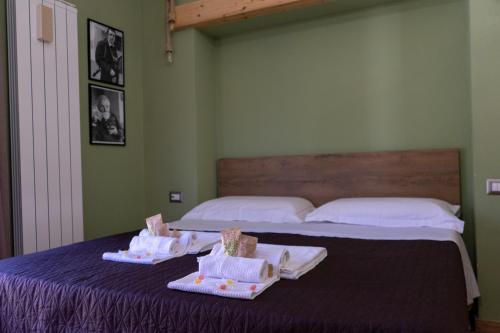 a bedroom with two beds with towels on a table at B&B Sud e Magia in Castelmezzano