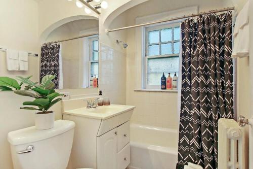 uma casa de banho com um lavatório, um WC e uma janela. em 1BR Relaxing Apartment in Downtown Skokie - Elm 2D em Skokie
