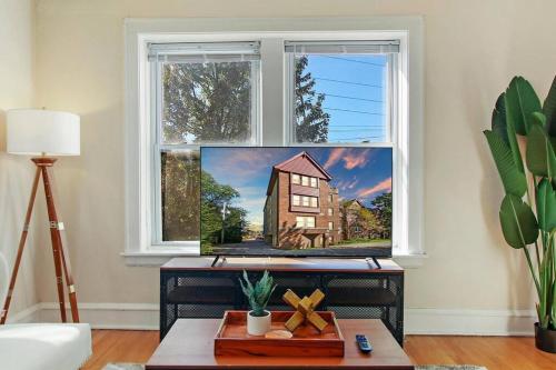 a living room with a window with a painting of a house at Complete & Polshed 1-Bedroom Chicago Apt - Elm D2 in Skokie