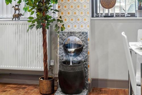 two potted trees sitting next to a water fountain at Luxury 1bed Studio Apt-City Centre-Wifi-Parking in Maidstone